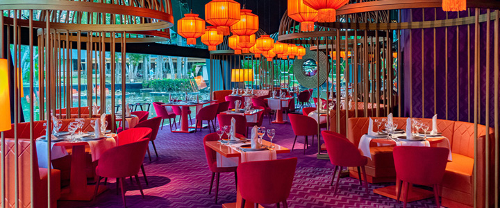 Modernes Restaurant im Hotel Grand Bavaro Princess in warmer Atmosphäre und gedeckten Tischen lädt zum Verweilen ein.